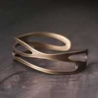 KarmaRipple's Vintage Gebogener Armreif aus Bronze-Messing mit Reichtumssymbol, verstellbar