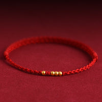 KarmaRipples 999 Goldperlen-Armband mit gewebtem Glückssymbol
