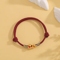 KarmaRipples gewebtes Armband mit roter Schnur und Bronzelegierung zum Jahr der Schlange