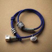 KarmaRipples handgefertigtes tibetisches Armband mit geschnitztem Om Mani Padme Hum-Amulett und doppelter Seilwicklung