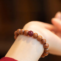 KarmaRipples Pfirsichholz-Lotus-Zinnober-Armband mit Glücks- und Reichtumssymbol